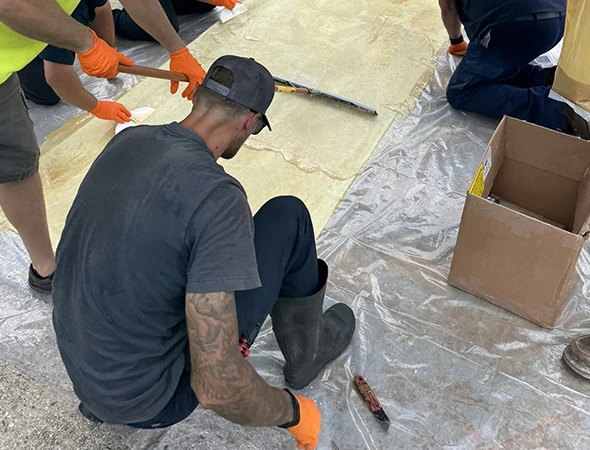 A group of men collaboratively working on a large paper, discussing plumbing plans and designs for a project.