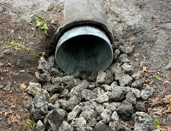 An underground pipe positioned next to rocks, representing trenchless pipe restoration methods for efficient repairs.