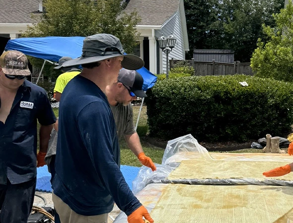 A team collaborates on a large wooden structure, showcasing their skills in trenchless plumbing techniques and teamwork.